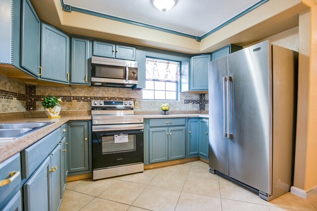 220 Mcdowell St, Bronte, TX 76933 - kitchen featuring appliances with stainless steel finishes, decorative backsplash, light tile patterned floors, and light countertops