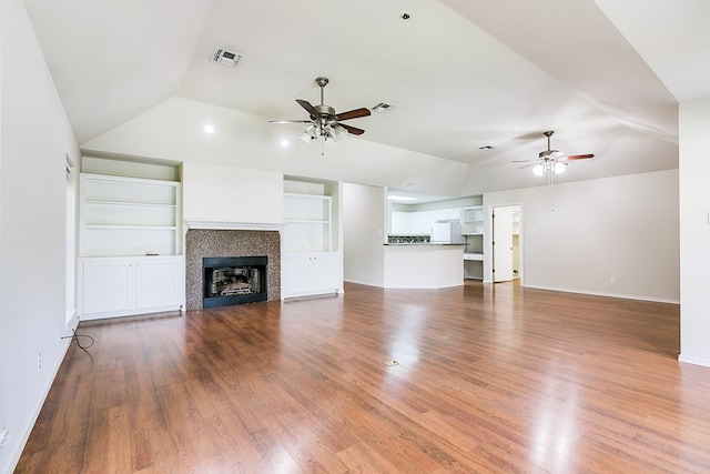 55 Southridge Dr, San Angelo, TX 76904 - unfurnished living room with ceiling fan, vaulted ceiling, wood finished floors, baseboards, and a tiled fireplace