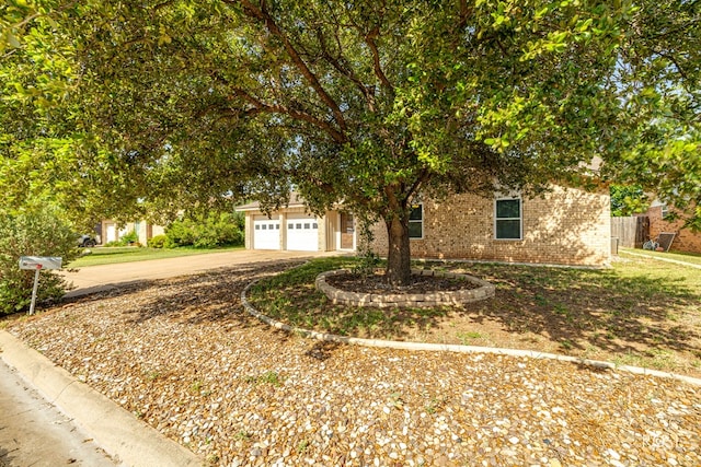 213 Amistad Rd, San Angelo, TX 76901 - obstructed view of property featuring brick siding, driveway, and an attached garage
