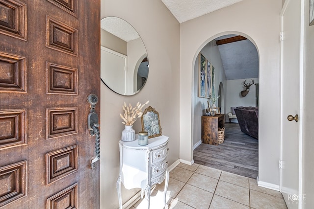 213 Amistad Rd, San Angelo, TX 76901 - entryway featuring arched walkways, light tile patterned flooring, and a textured ceiling