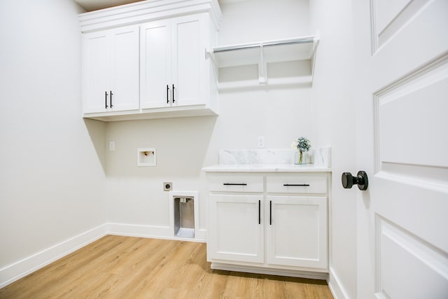 3609 Clearview Dr, San Angelo, TX 76904 - washroom featuring light wood-style floors, hookup for a washing machine, hookup for an electric dryer, and cabinet space