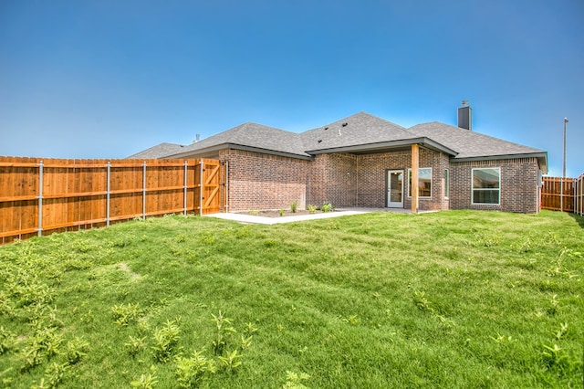 3609 Clearview Dr, San Angelo, TX 76904 - back of property featuring a fenced backyard, brick siding, a shingled roof, and a chimney