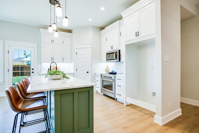 3609 Clearview Dr, San Angelo, TX 76904 - kitchen with appliances with stainless steel finishes, a kitchen island with sink, light wood-type flooring, white cabinets, and recessed lighting