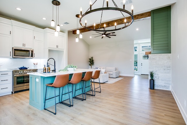 3609 Clearview Dr, San Angelo, TX 76904 - kitchen featuring appliances with stainless steel finishes, a chandelier, open floor plan, white cabinetry, and light countertops