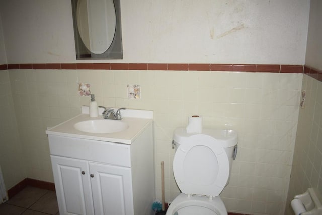 bathroom featuring vanity, tile walls, tile patterned floors, and toilet