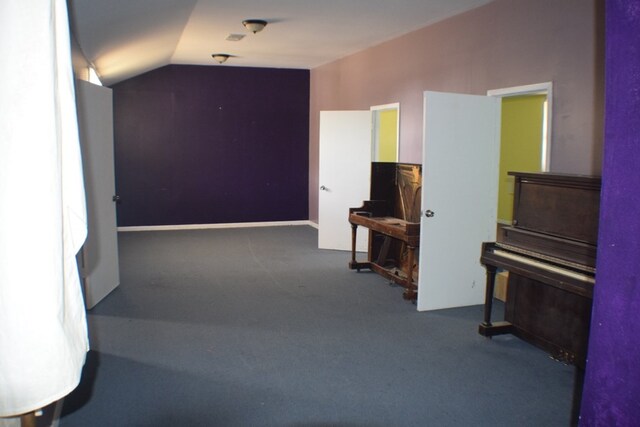 interior space featuring vaulted ceiling and carpet flooring