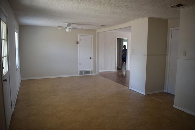 unfurnished room with ceiling fan and a textured ceiling