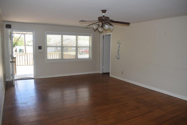 empty room featuring dark wood-type flooring, ornamental molding, and ceiling fan