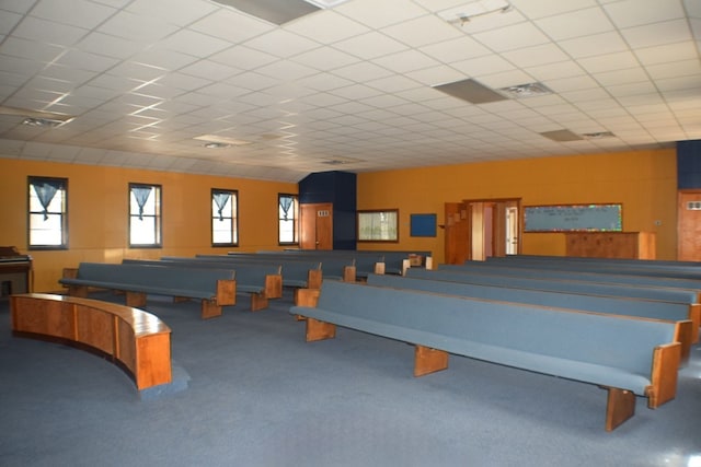 game room with a paneled ceiling and carpet flooring