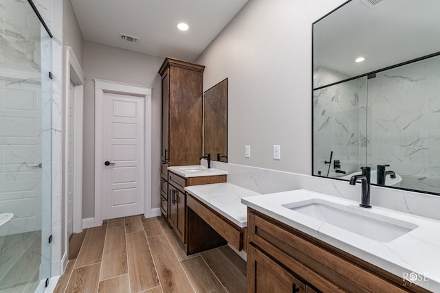 2301 Hillside Dr, San Angelo, TX 76904 - bathroom featuring vanity, a marble finish shower, wood finish floors, and recessed lighting