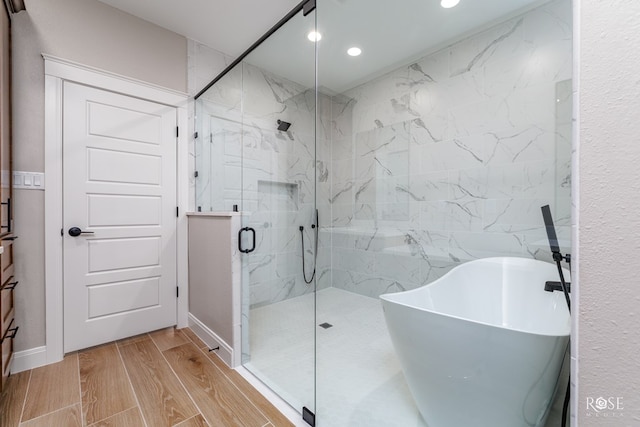 2301 Hillside Dr, San Angelo, TX 76904 - bathroom with a freestanding tub, a marble finish shower, recessed lighting, wood finished floors, and a sink