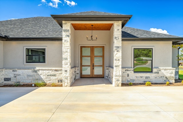2301 Hillside Dr, San Angelo, TX 76904 - doorway to property featuring stone siding, a shingled roof, french doors, and stucco siding