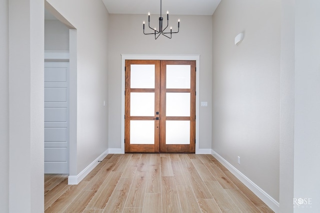 2301 Hillside Dr, San Angelo, TX 76904 - doorway with a chandelier, french doors, light wood-style floors, and baseboards