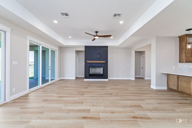 2301 Hillside Dr, San Angelo, TX 76904 - unfurnished living room with ceiling fan, baseboards, recessed lighting, a tray ceiling, and a fireplace
