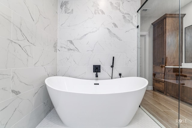 2301 Hillside Dr, San Angelo, TX 76904 - bathroom featuring a freestanding bath and tile walls