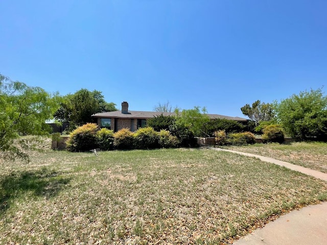 165 Edinburgh Rd, San Angelo, TX 76901 - view of front of home featuring a chimney and a front yard