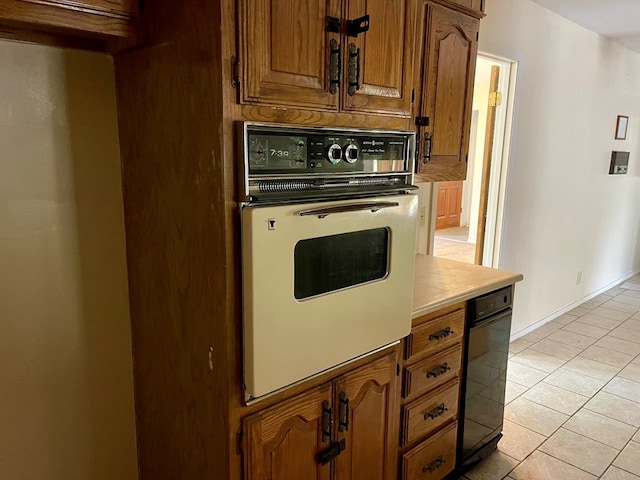 165 Edinburgh Rd, San Angelo, TX 76901 - kitchen featuring light tile patterned flooring, brown cabinets, oven, and light countertops