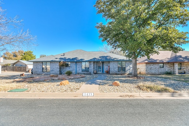 view of front of home with brick siding and fence