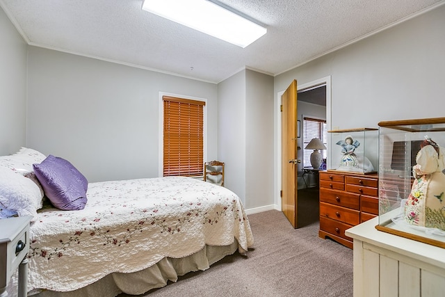 carpeted bedroom with ornamental molding and a textured ceiling