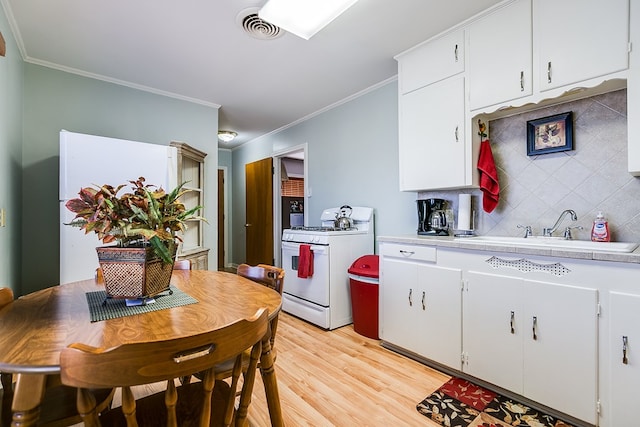 kitchen featuring backsplash, sink, white range with gas stovetop, and white cabinets