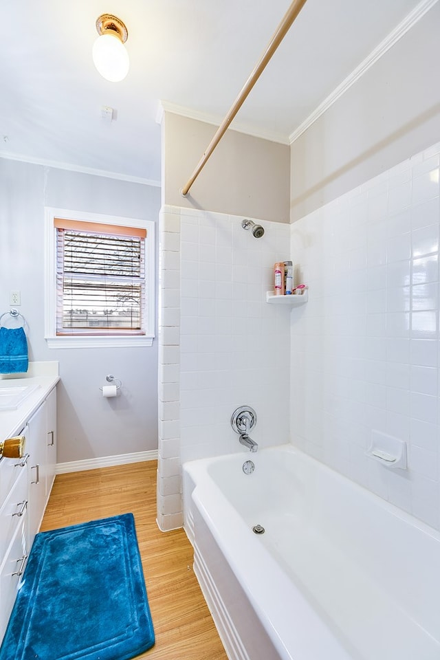 bathroom with crown molding, tiled shower / bath, vanity, and hardwood / wood-style floors