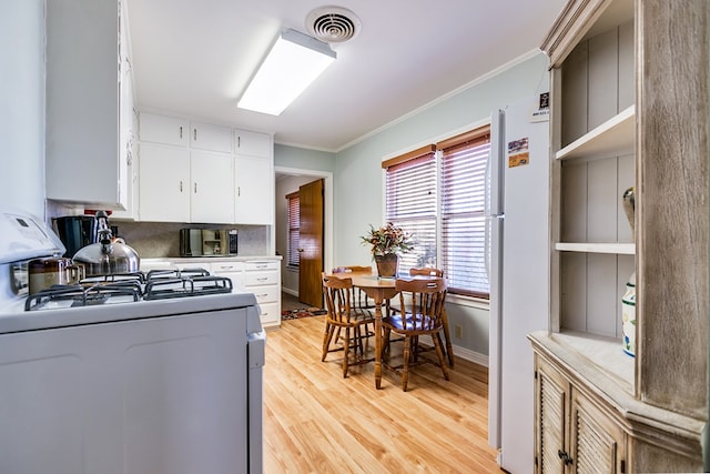 kitchen featuring crown molding, white appliances, light hardwood / wood-style flooring, white cabinetry, and backsplash