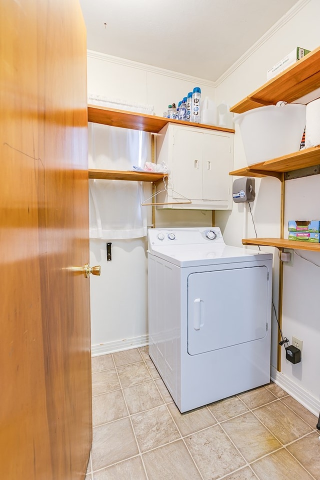 washroom with crown molding, cabinets, washer / dryer, and light tile patterned floors