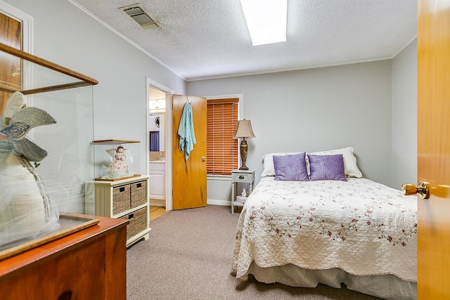 bedroom with crown molding, light colored carpet, a textured ceiling, and ensuite bath