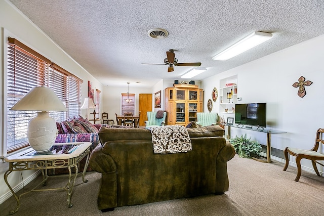 living room with ceiling fan, carpet floors, and a textured ceiling