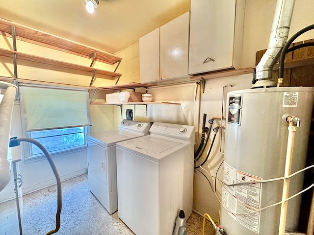 clothes washing area with water heater, washer and dryer, and cabinets