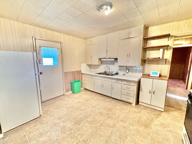 kitchen featuring decorative backsplash, sink, and white fridge