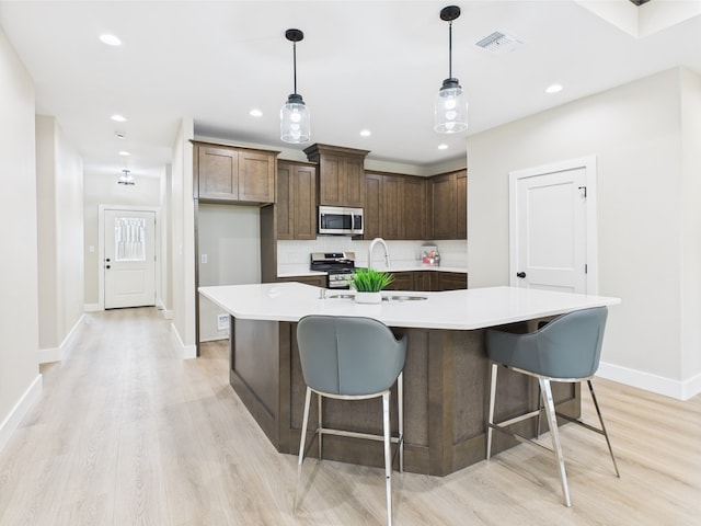 1942 Pine Valley St, San Angelo, TX 76904 - kitchen featuring stainless steel appliances, light wood-style floors, tasteful backsplash, light countertops, and recessed lighting