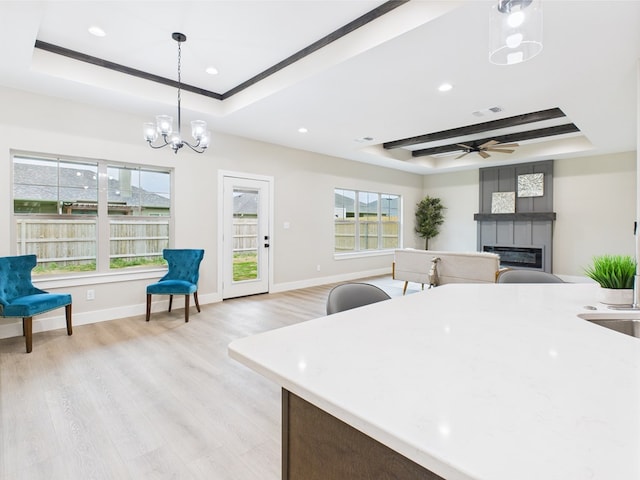 1942 Pine Valley St, San Angelo, TX 76904 - kitchen with a raised ceiling, a large fireplace, light wood-style floors, decorative light fixtures, and recessed lighting