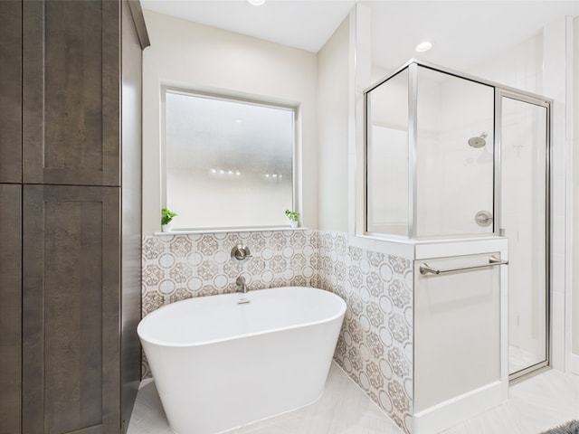 1942 Pine Valley St, San Angelo, TX 76904 - bathroom featuring a freestanding tub, a shower stall, tile walls, and wainscoting