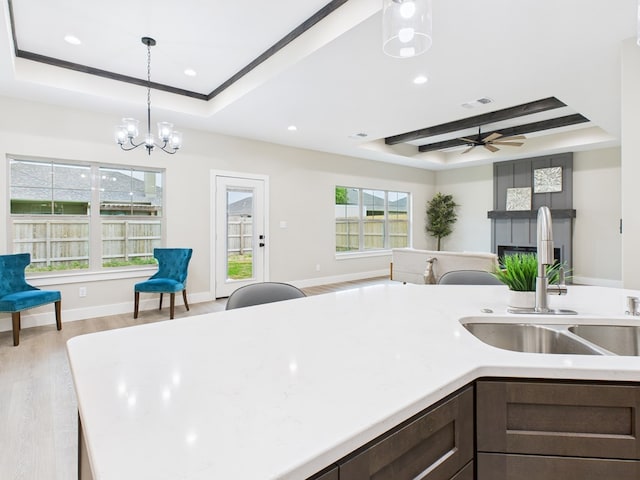 1942 Pine Valley St, San Angelo, TX 76904 - kitchen with a tray ceiling, open floor plan, dark brown cabinetry, light countertops, and recessed lighting
