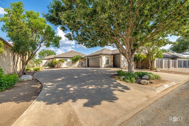 2141 Valleyview Dr, San Angelo, TX 76904 - view of front of house featuring concrete driveway, an attached garage, and stone siding