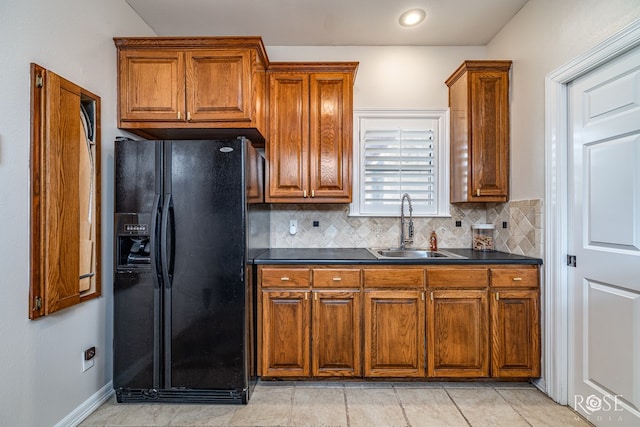 2141 Valleyview Dr, San Angelo, TX 76904 - kitchen featuring black fridge, a sink, dark countertops, and brown cabinetry
