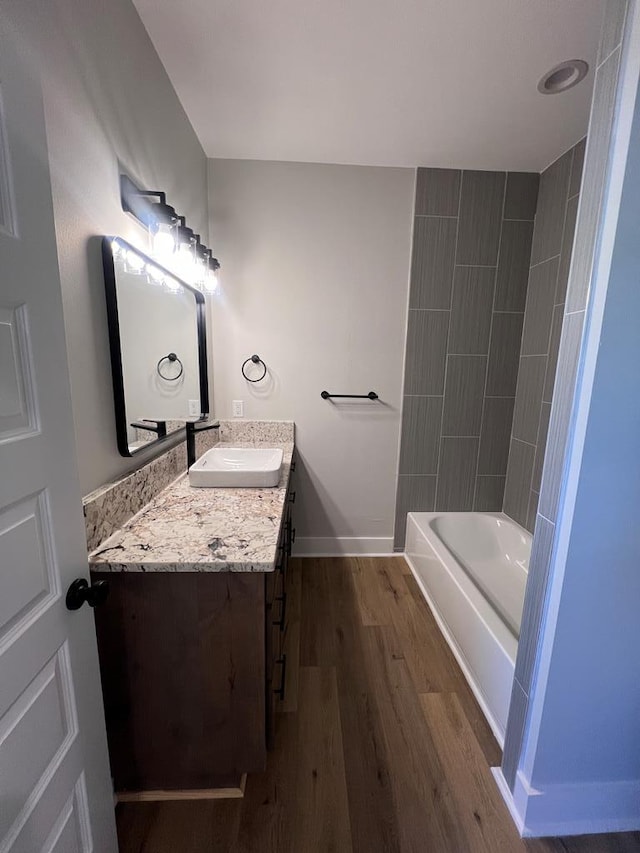 bathroom featuring vanity, tiled shower / bath combo, and wood-type flooring