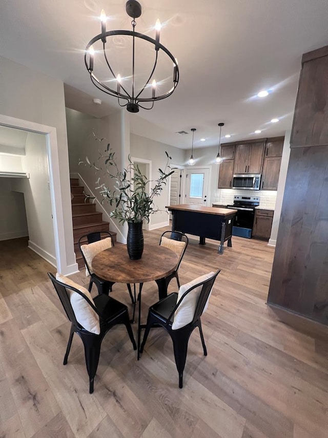 dining room with a chandelier and light hardwood / wood-style flooring