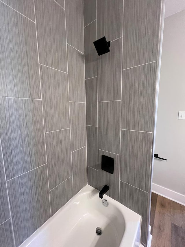 bathroom featuring hardwood / wood-style flooring and bathtub / shower combination