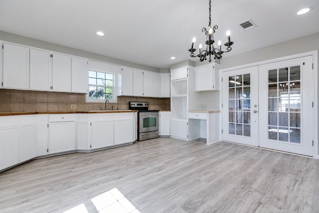 kitchen featuring pendant lighting, sink, stainless steel electric range, white cabinets, and decorative backsplash