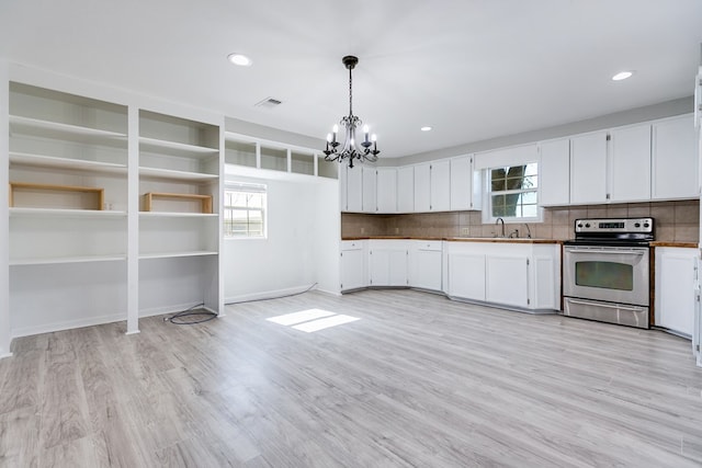 kitchen with stainless steel range with electric stovetop, decorative light fixtures, and white cabinetry