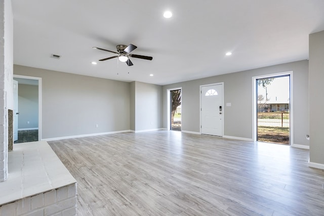 unfurnished living room featuring ceiling fan and light wood-type flooring