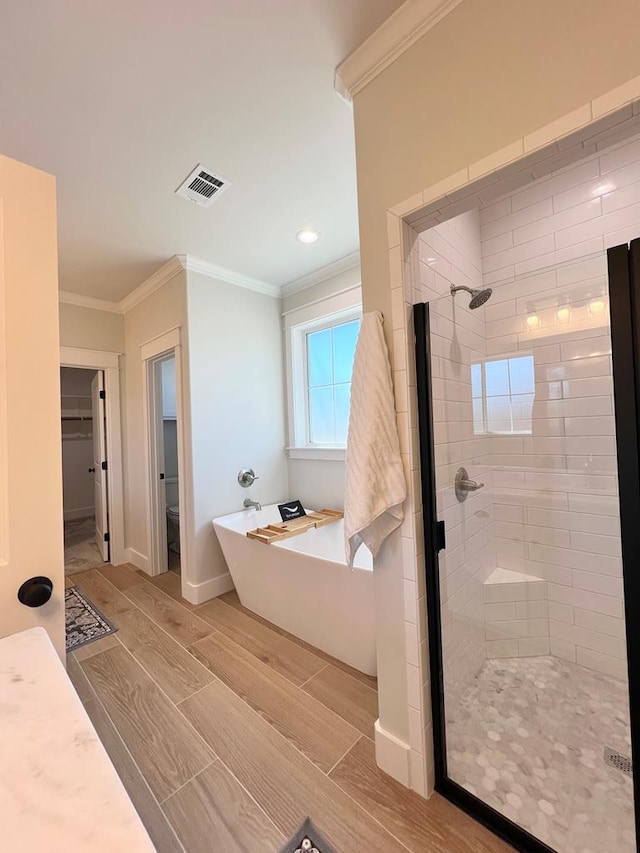 bathroom with ornamental molding and plus walk in shower