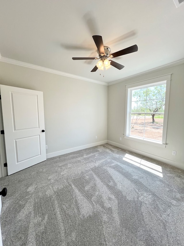 carpeted spare room with ornamental molding and ceiling fan