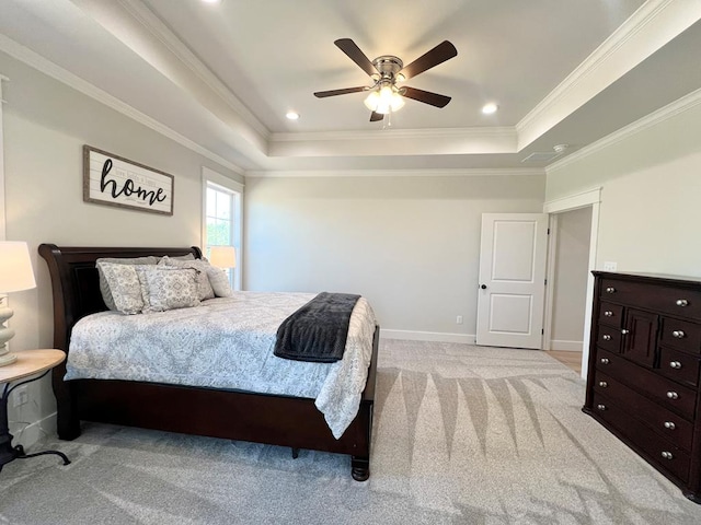 bedroom featuring light carpet, a tray ceiling, ornamental molding, and ceiling fan