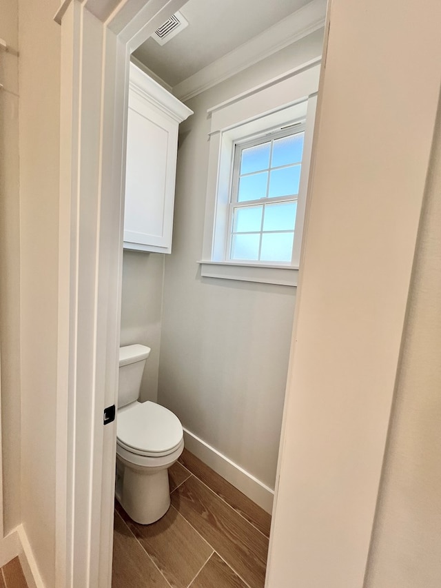 bathroom with ornamental molding and toilet