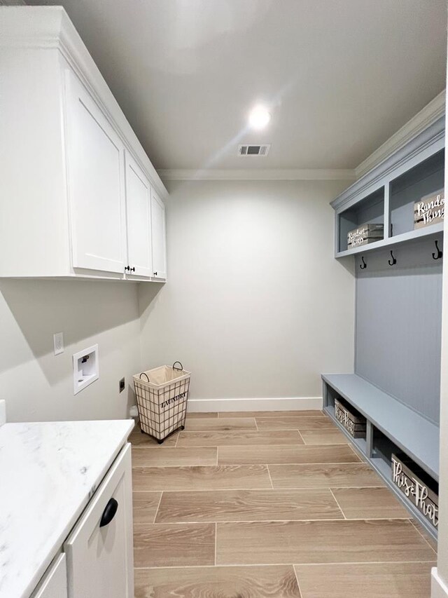 washroom with cabinets, crown molding, washer hookup, and hookup for an electric dryer