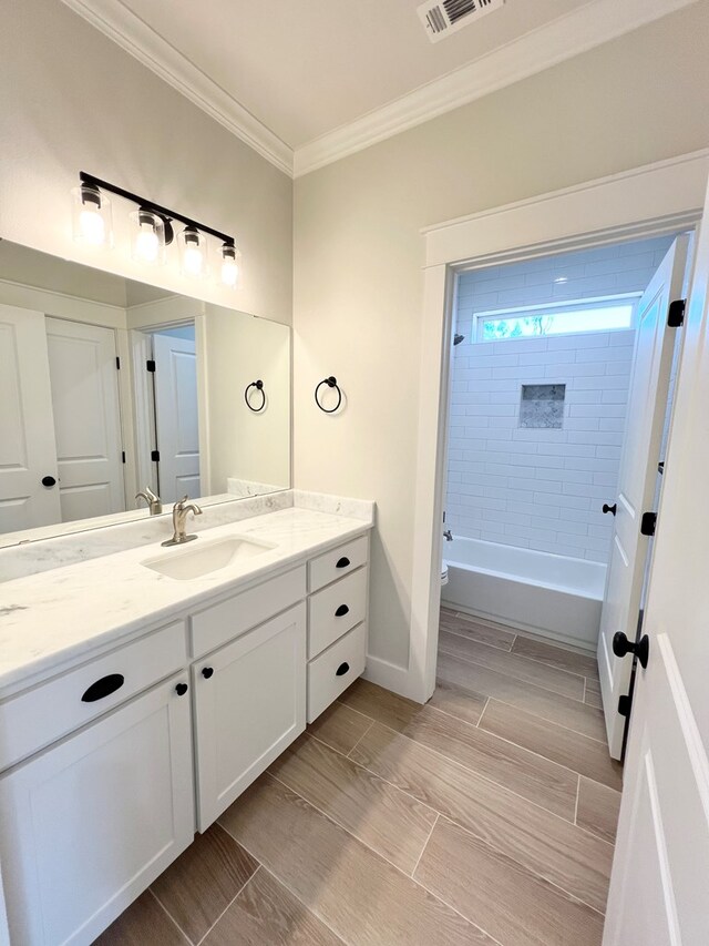 bathroom featuring ornamental molding, vanity, and washtub / shower combination