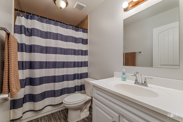 bathroom with curtained shower, toilet, wood finished floors, vanity, and visible vents